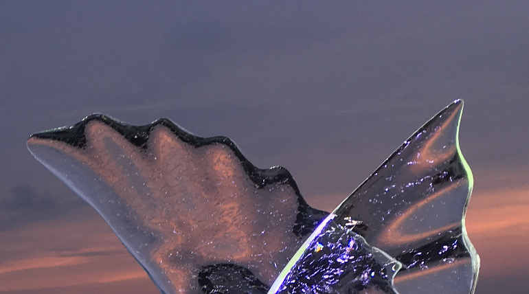 The Sculptor by Judy Darley. Photo of an ice sculpture against a sunset.