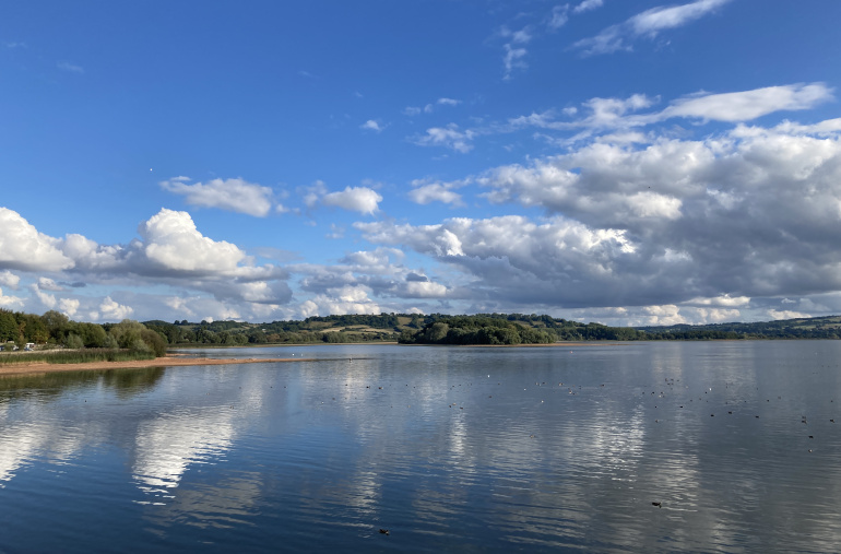 Chew Magna Lake_By Judy Darley. Blue sky, white clouds and reflections in lake water.