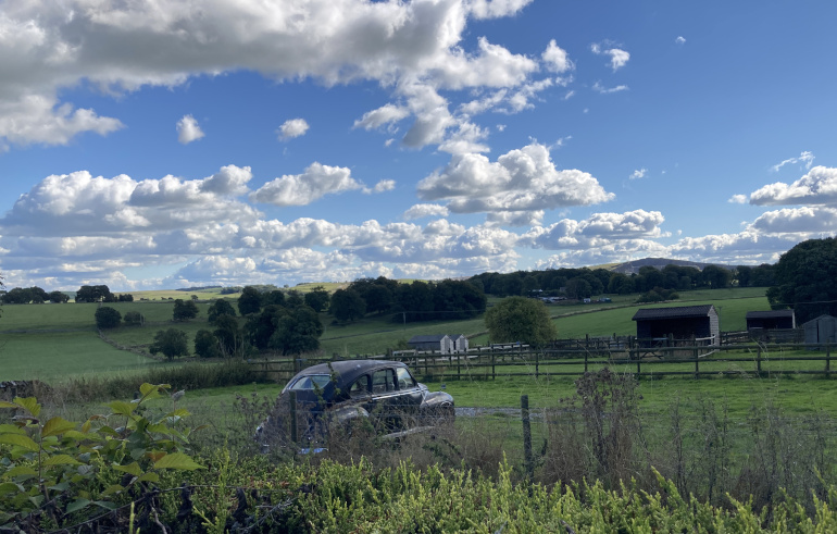 Staden Grange, our home in Buxton, VW Beetle car in green field. Photo by Judy Darley