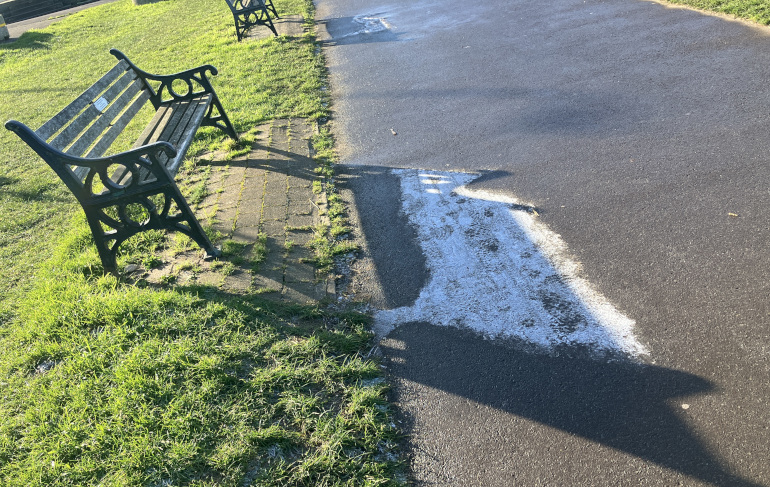 Ice in the shadow of a bench.
